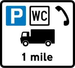 Distance to a commercial vehicles parking place ahead with public toilets and telephones — UK road sign