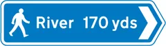 Distance and direction of route to destination shown for pedestrians — UK road sign