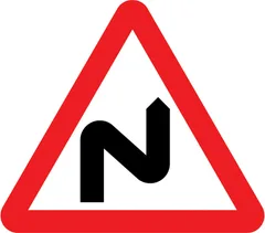 Double bend or series of bends ahead, first to the right — UK road sign