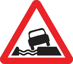 Water course alongside road ahead — UK road sign